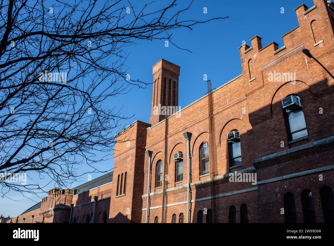 An urban street scene featuring a brick building with a clear blue sky in the background Stock Photo