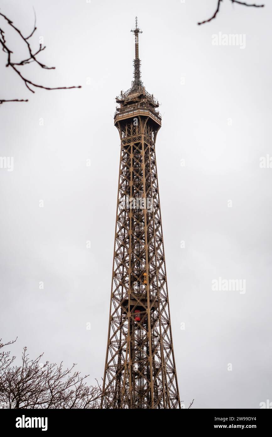 Autumn branches on the Eiffel Tower in Paris with its 2 rising elevators - France Stock Photo