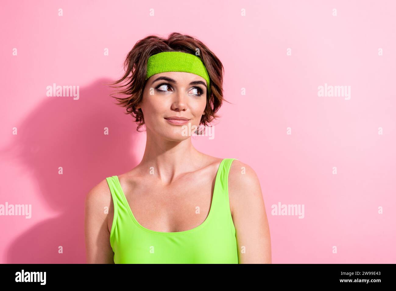 Photo of adorable thoughtful lady dressed green bodysuit looking empty space isolated pink color background Stock Photo