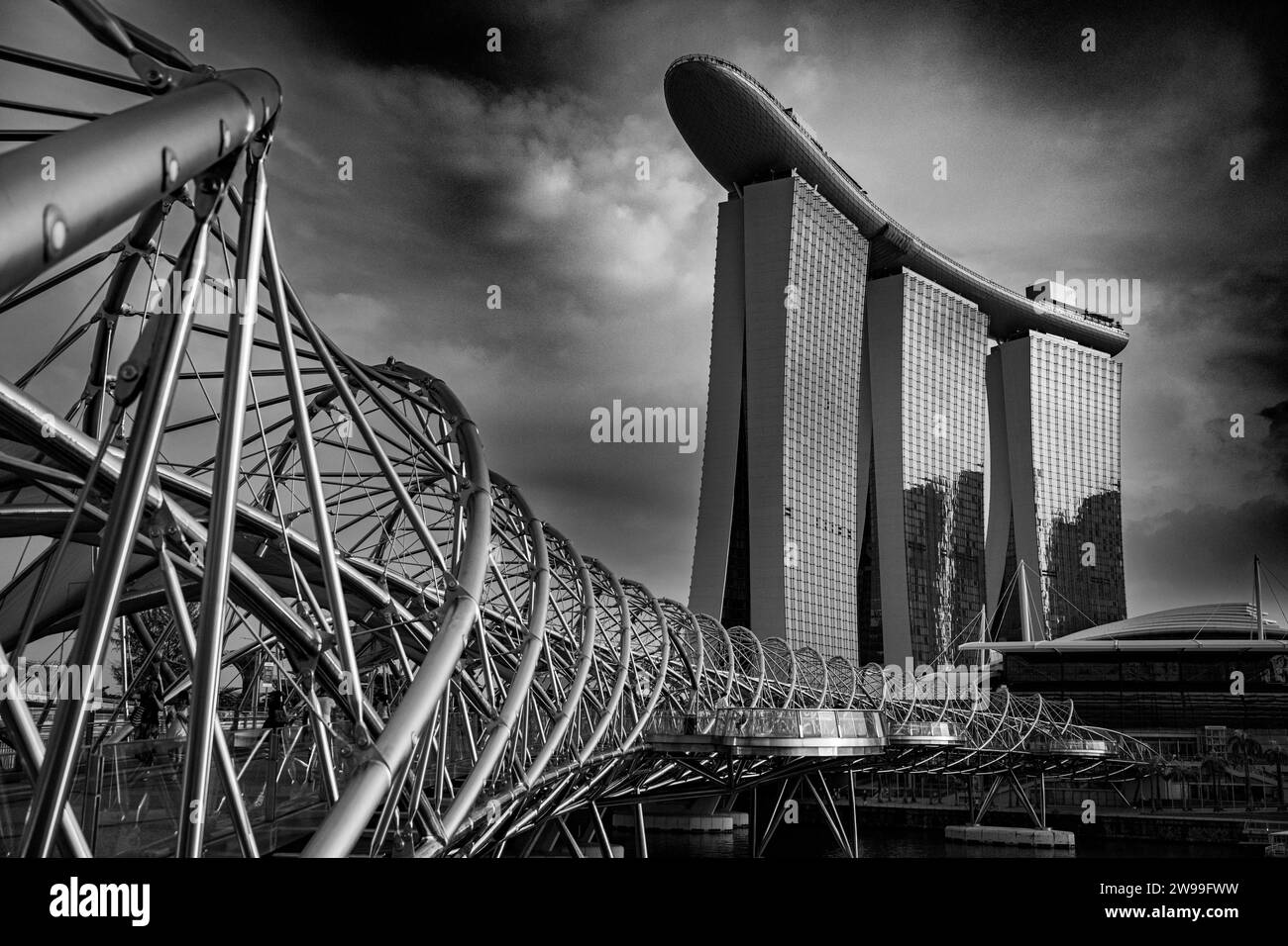 A modern cityscape of Singapore, with a bridge spanning across two tall buildings in black and white Stock Photo