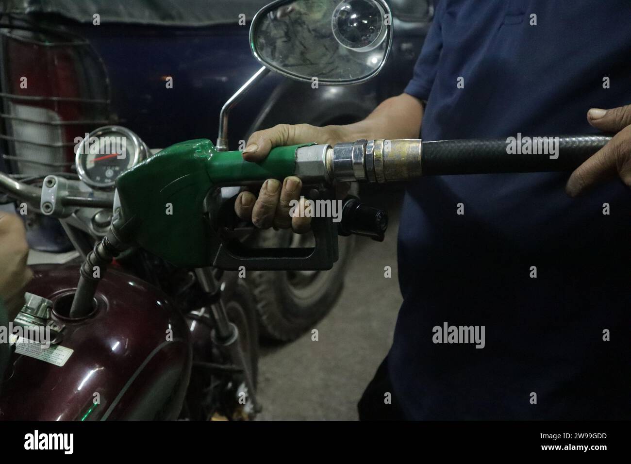 Dhaka, Bangladesh. 26th Dec, 2023. A motorcycle rider holds Bangladeshi Taka bank notes to pay for fuel at a fuel station in Dhaka. (Credit Image: © MD Mehedi Hasan/ZUMA Press Wire) EDITORIAL USAGE ONLY! Not for Commercial USAGE! Stock Photo