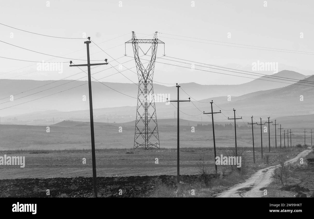 Empowering the rural grid. transmission power line infrastructure for remote communities. Black and white, monochrome. Stock Photo