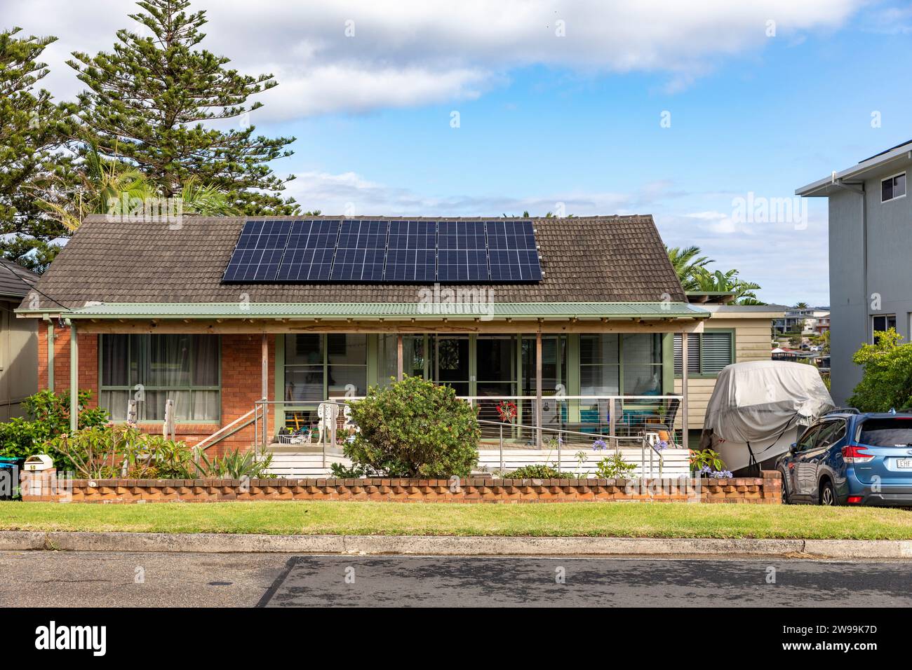 Home in Warriewood Sydney Australia, traditional bungalow style home with PV solar panels on the roof providing solar power to the house. Stock Photo