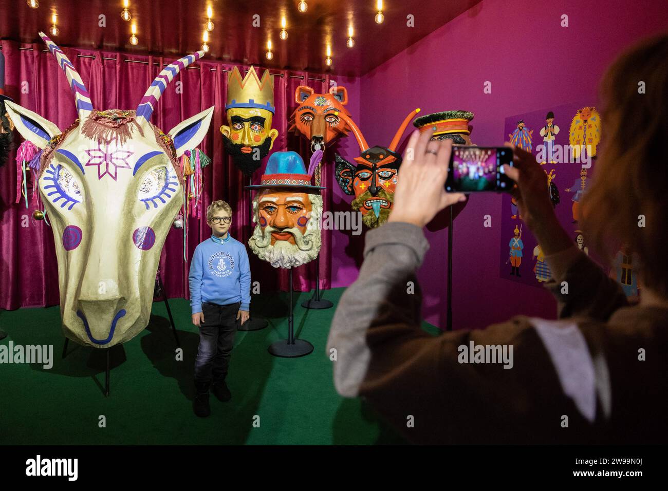 Kyiv, Ukraine. 24th Dec, 2023. Visitors take photos of giant nativity