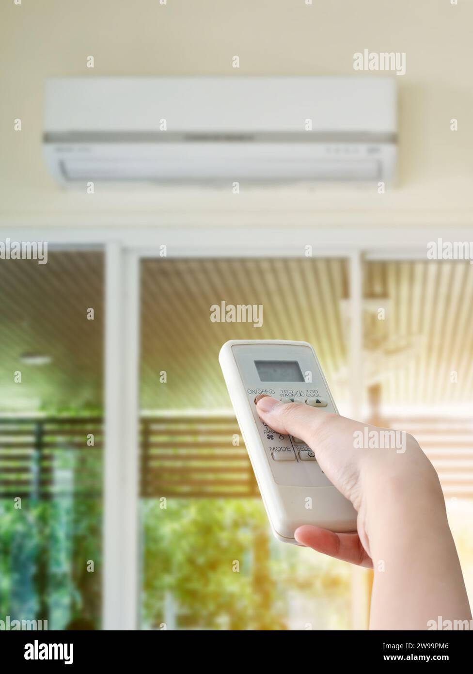 Hand hold remote control directed on the air conditioner Stock Photo