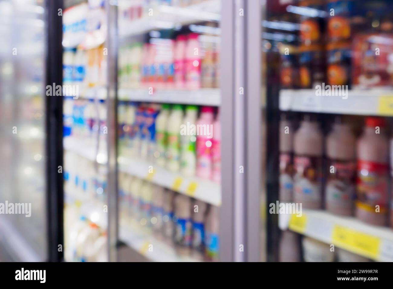 blur dairy product milk bottles on refrigerator shelf in supermarket Stock Photo