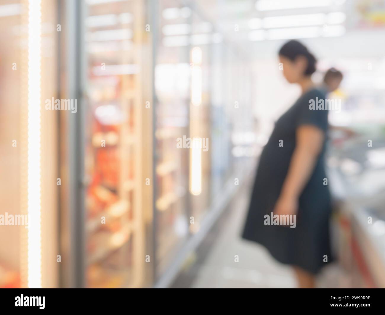 Blur pregnant woman at Frozen food section in supermarket Stock Photo