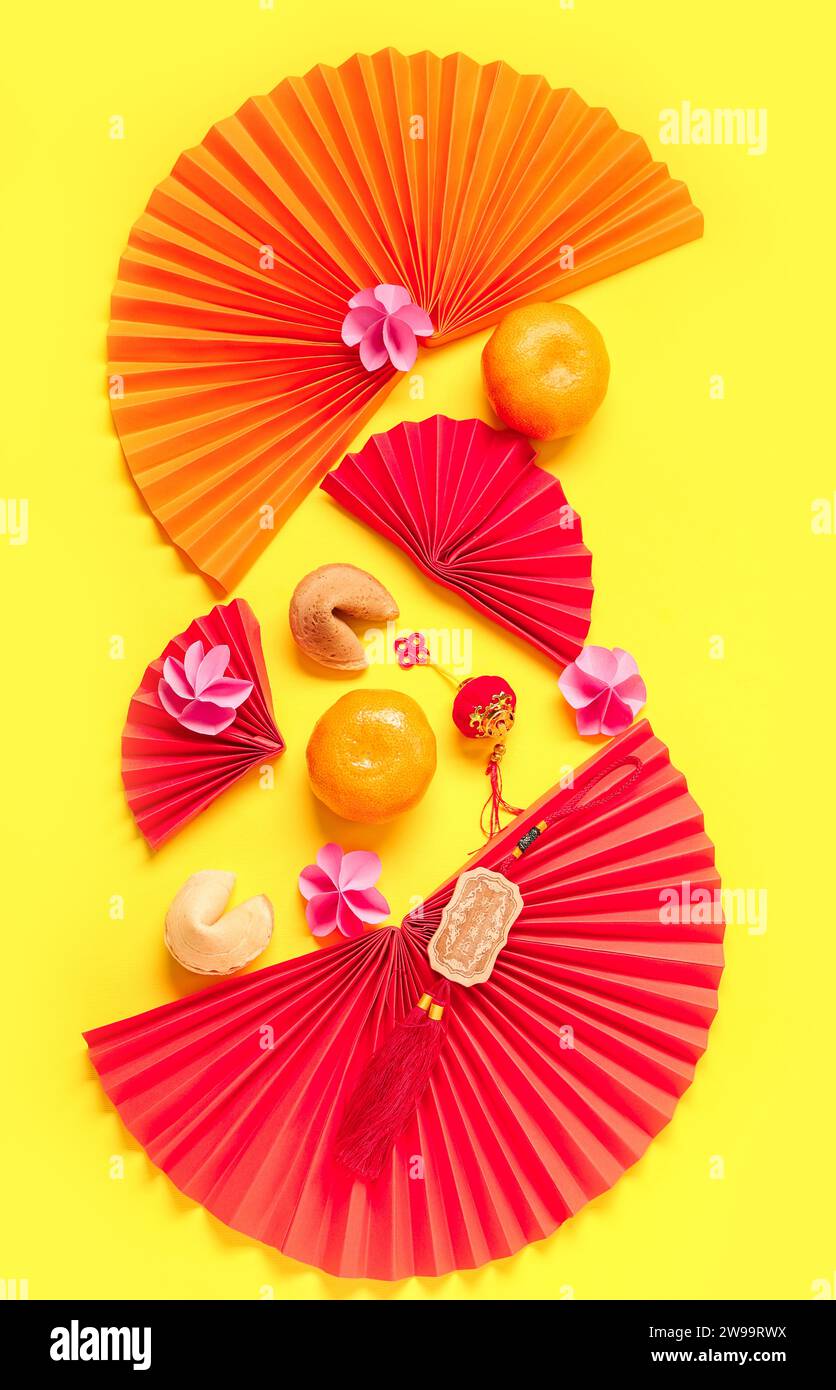 Chinese symbols with tangerines, flowers and fortune cookies on yellow
