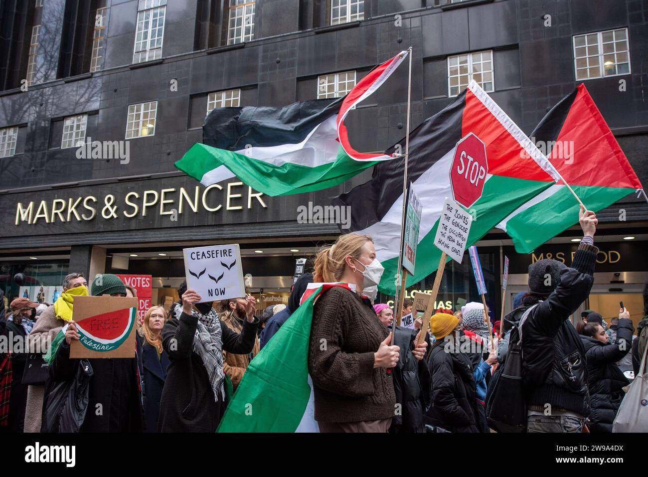 London UK 23rd Dec 2023 Protesters Pass By The Mark Spencer Store london-uk-23rd-dec-2023-protesters-pass-by-the-mark-spencer-store