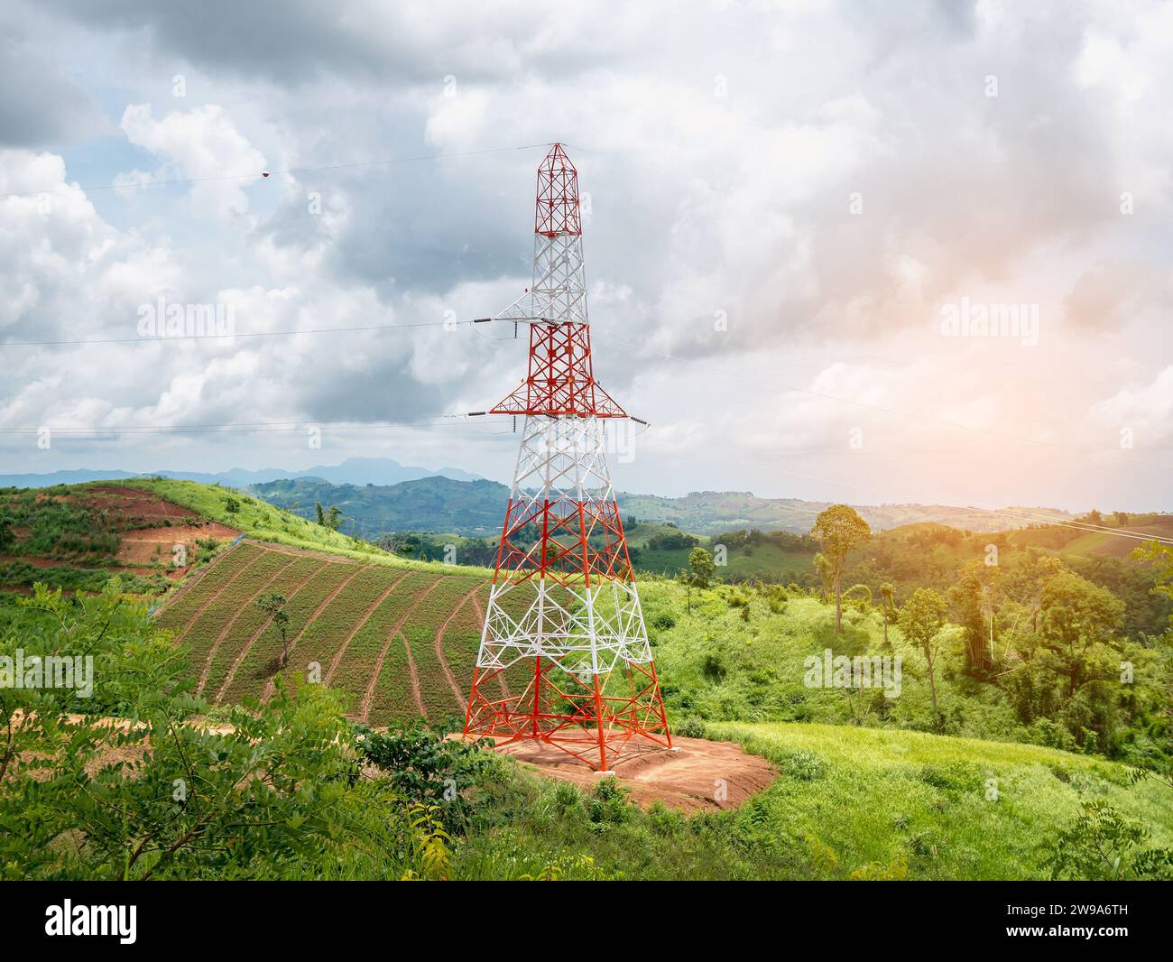 High voltage power lines tower on green mountain and sky with clouds ...