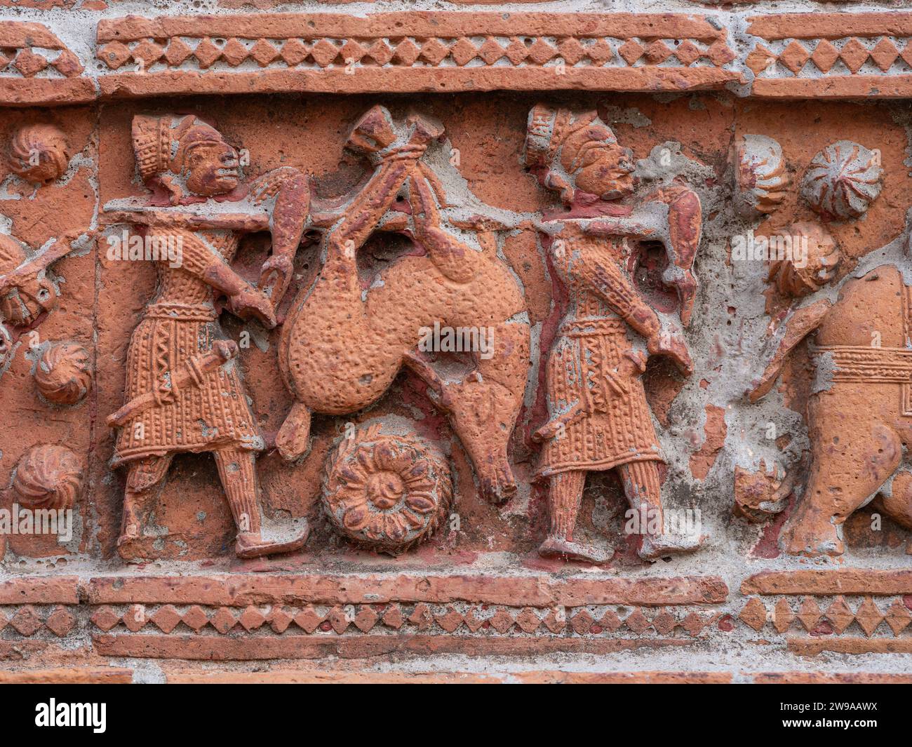 Closeup view of carved terracotta hunting scene of hunters carrying deer on ancient Govinda temple in Puthia religious complex, Rajshahi, Bangladesh Stock Photo