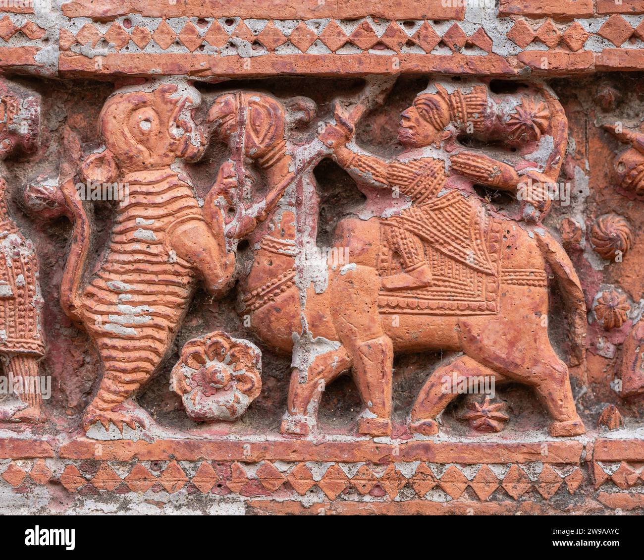 Closeup view of carved terracotta hunting scene with camel and tiger on ancient Govinda temple in Puthia religious complex, Rajshahi, Bangladesh Stock Photo