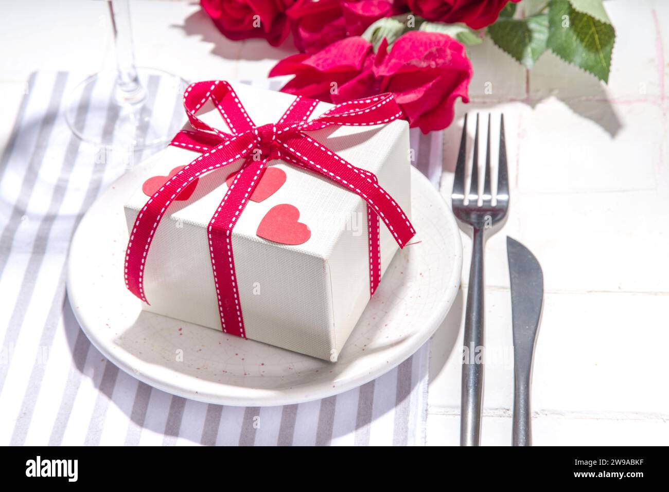 Valentine day table setting with plate, gift box with festive red ...