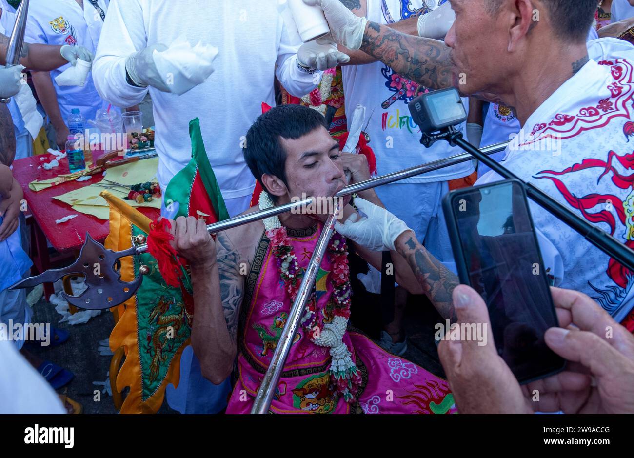A devotee gets pierced at Bang Neow Shrine during the annual Vegetarian Festival in Phuket Town, Thailand. Thailand's tourism numbers are on track in Stock Photo