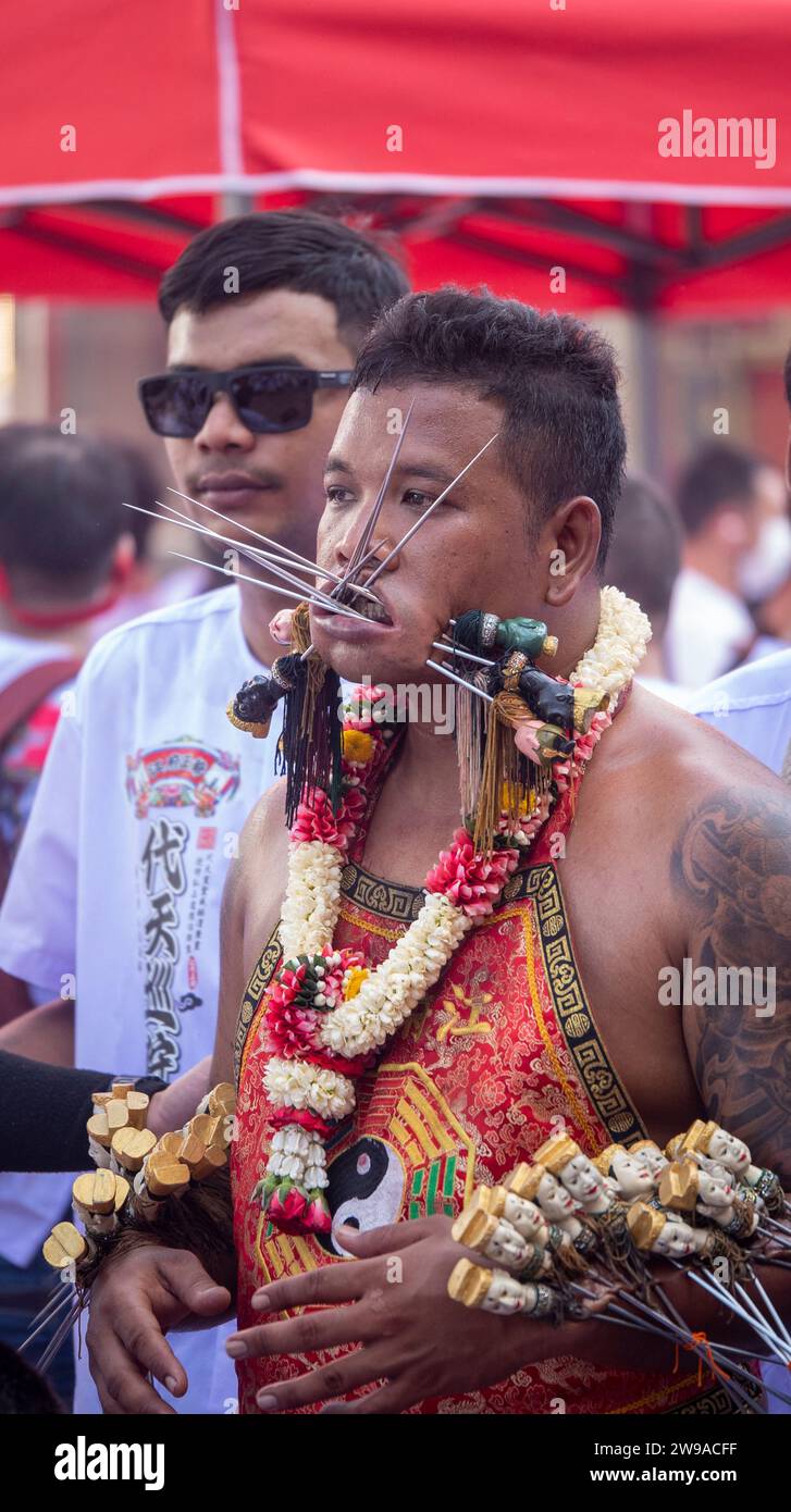 Pierced devotees walk in a procession during the annual Vegetarian Festival in Phuket Town, Thailand. Thailand's tourism numbers are on track in 2023 Stock Photo