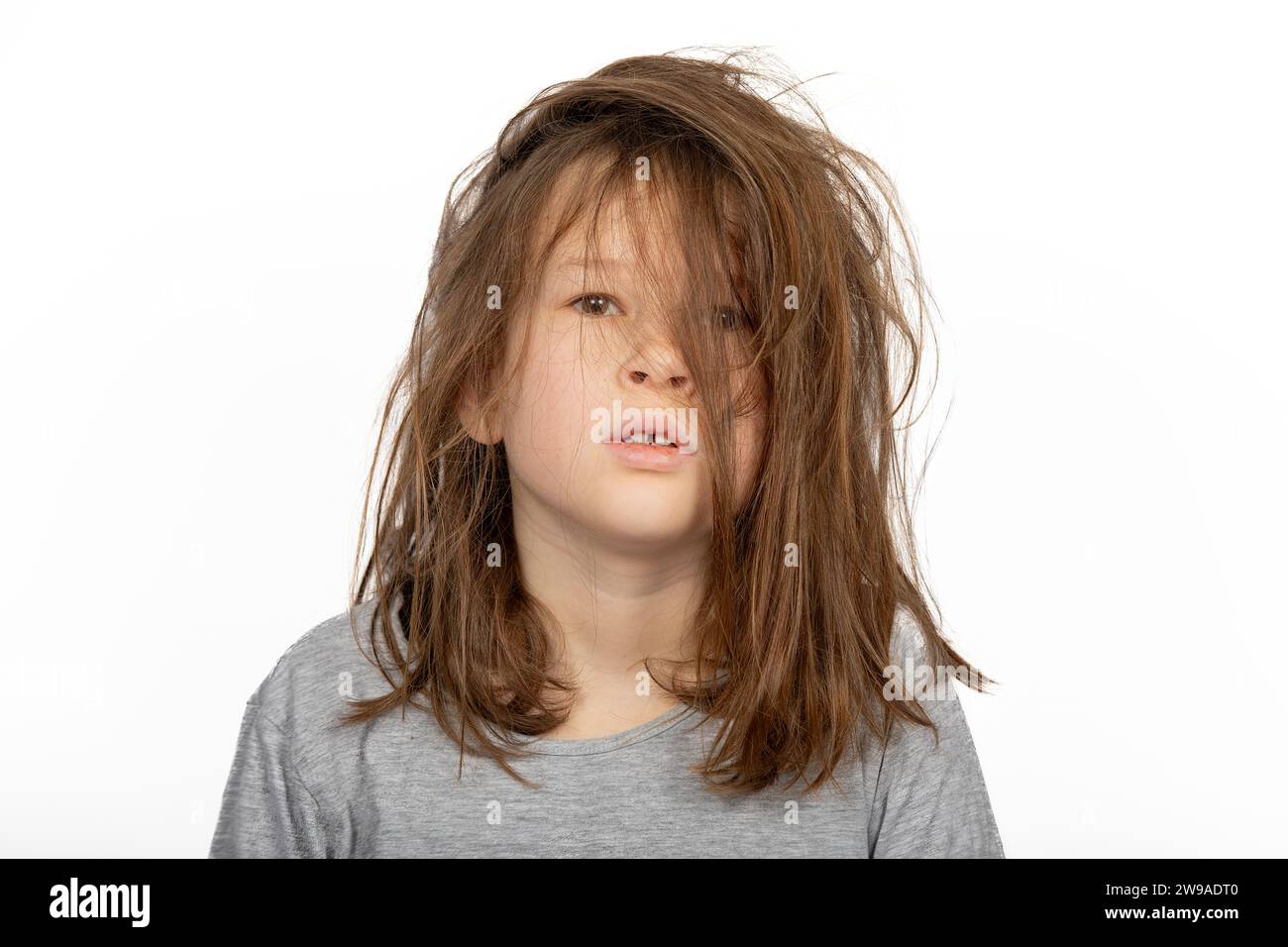 Grumpy Christmas Morning: Portrait of Young Girl with a Bad Hair Day on White Background Stock Photo