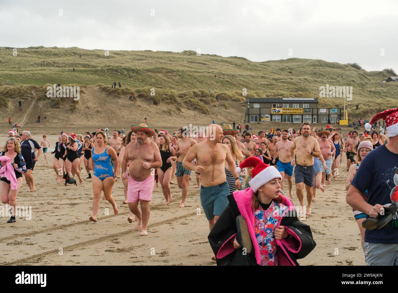 Perranporth, Cornwall, UK. 26th December 2023. UK Weather. Hundreds of people turned out in the mild weather for the annual 'no wetsuit' boxing day swim at Perranporth in Cornwall this morning. Credit Simon Maycock / Alamy Live News. Stock Photo