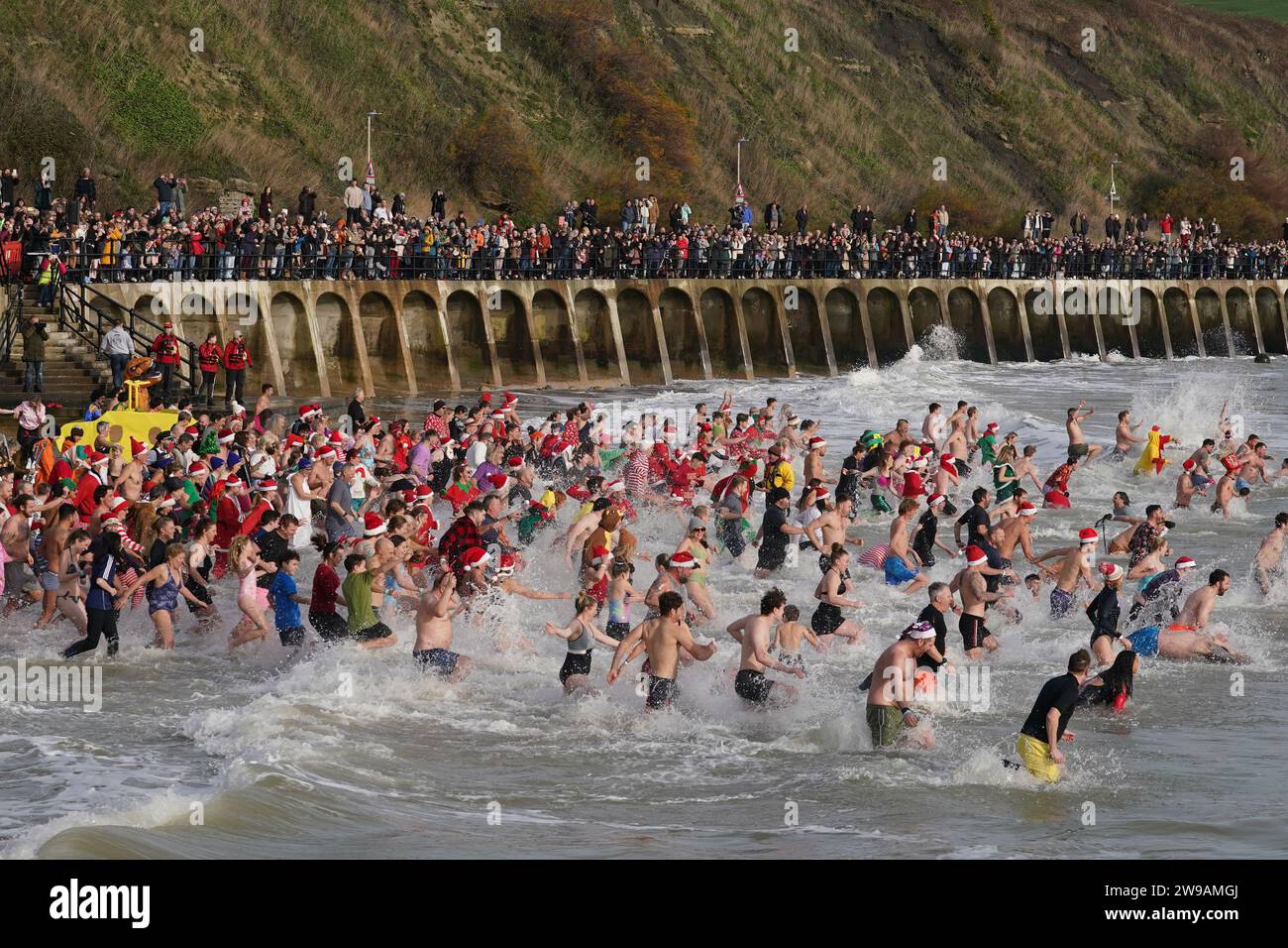 Swimmers take part in the Folkestone Lions' Boxing Day Dip at Sunny Sands Beach in Folkestone, Kent. Picture date: Tuesday December 26, 2023. Stock Photo