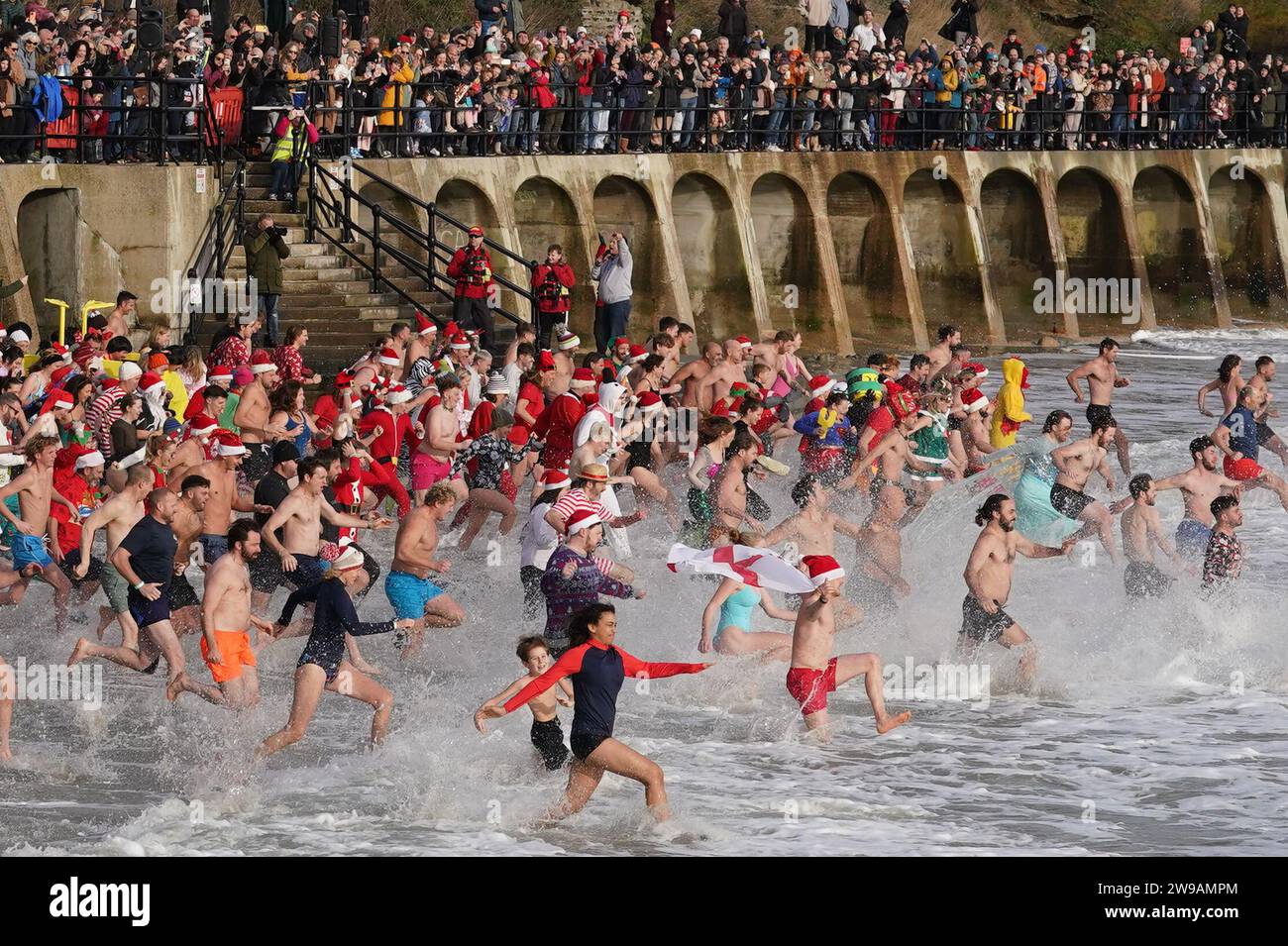 Swimmers take part in the Folkestone Lions' Boxing Day Dip at Sunny Sands Beach in Folkestone, Kent. Picture date: Tuesday December 26, 2023. Stock Photo