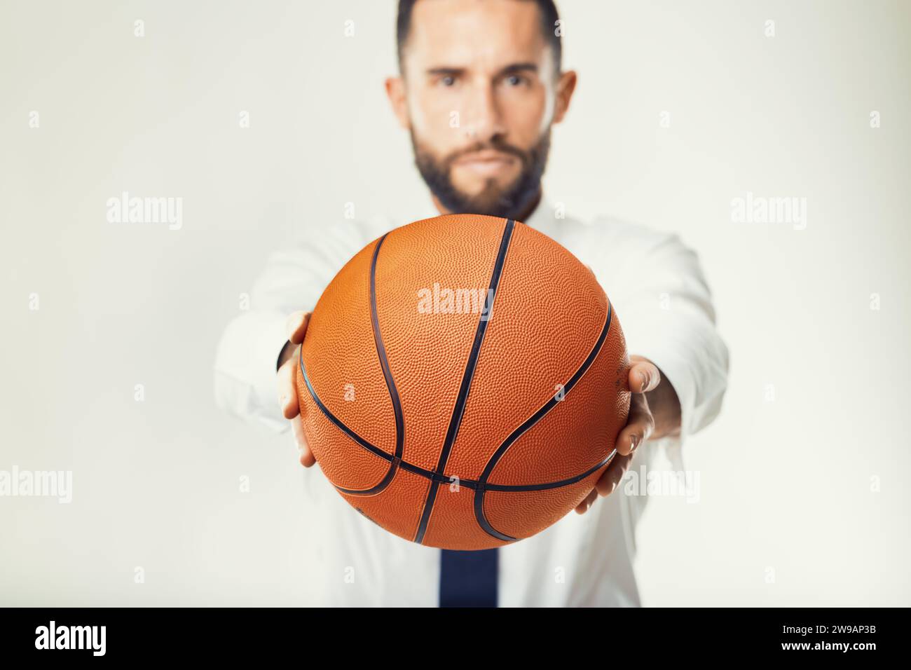 Business professional holds a basketball, illustrating the intersection