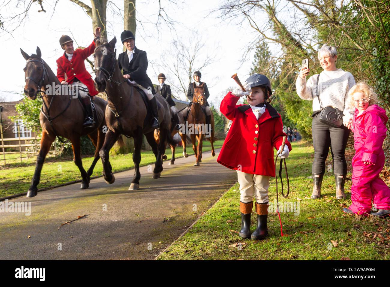 Hagley, Worcestershire, UK. 26th Dec, 2023. 4 year old Myla Mills welcomes the hunt riders and hounds at Albrighton and Woodland Hunt's Boxing Day meet at Hagley Hall, Worcestershire. Credit: Peter Lopeman/Alamy Live News Stock Photo