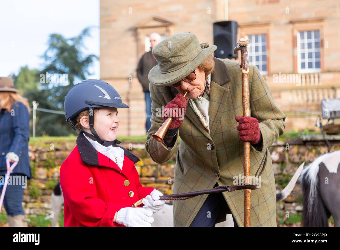 Hagley, Worcestershire, UK. 26th Dec, 2023. 4 year old Myla Mills is shown how to blow a horn by Hazel Sheppard at the Albrighton and Woodland Hunt's Boxing Day meet at Hagley Hall, Worcestershire. Credit: Peter Lopeman/Alamy Live News Stock Photo