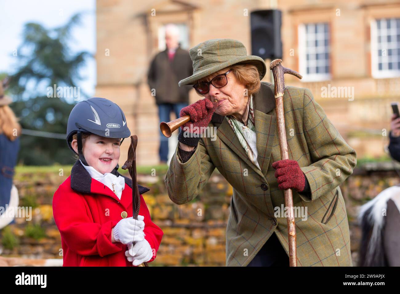 Hagley, Worcestershire, UK. 26th Dec, 2023. 4 year old Myla Mills is shown how to blow a horn by Hazel Sheppard at the Albrighton and Woodland Hunt's Boxing Day meet at Hagley Hall, Worcestershire. Credit: Peter Lopeman/Alamy Live News Stock Photo