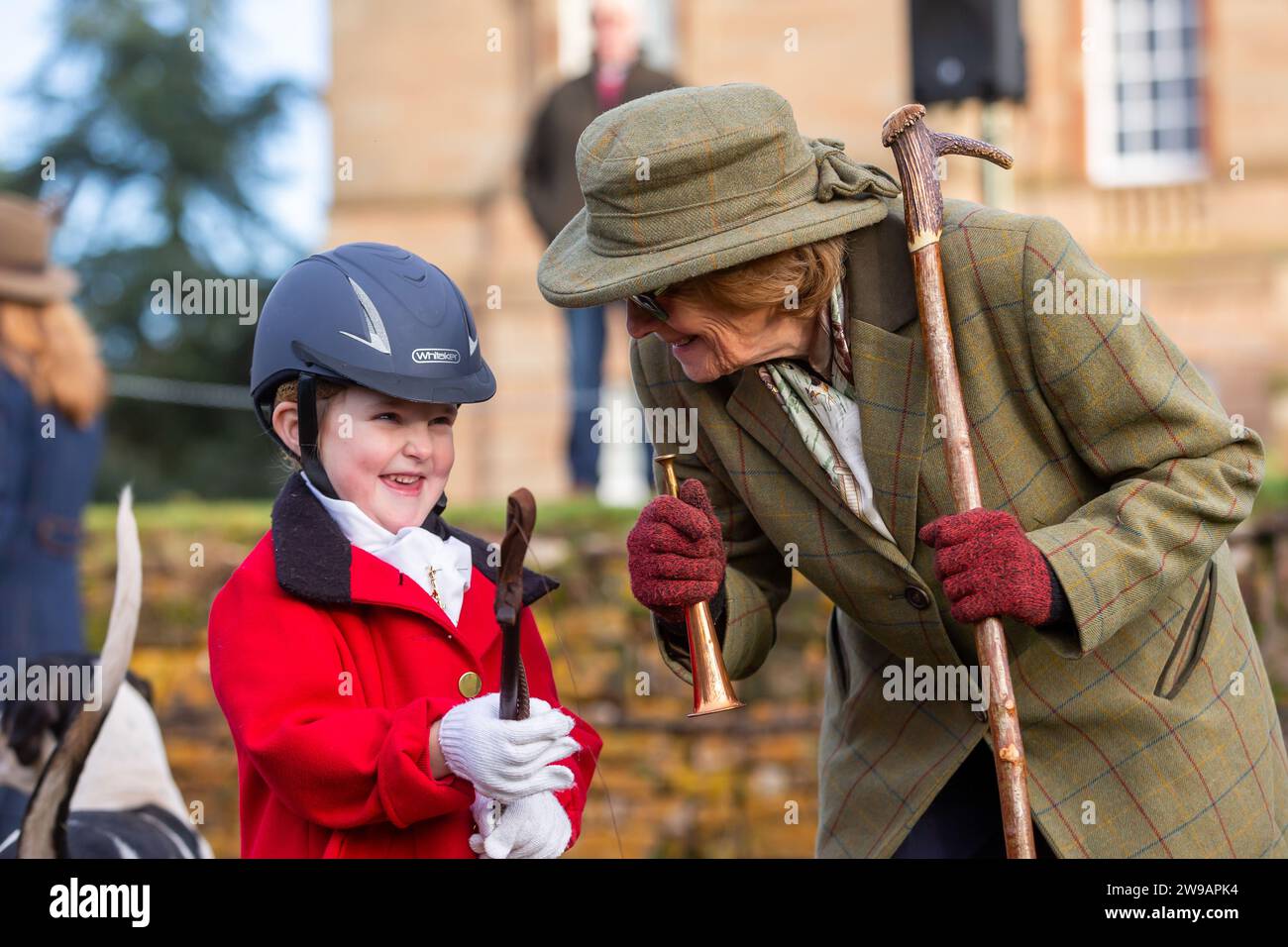 Hagley, Worcestershire, UK. 26th Dec, 2023. 4 year old Myla Mills is shown how to blow a horn by Hazel Sheppard at the Albrighton and Woodland Hunt's Boxing Day meet at Hagley Hall, Worcestershire. Credit: Peter Lopeman/Alamy Live News Stock Photo