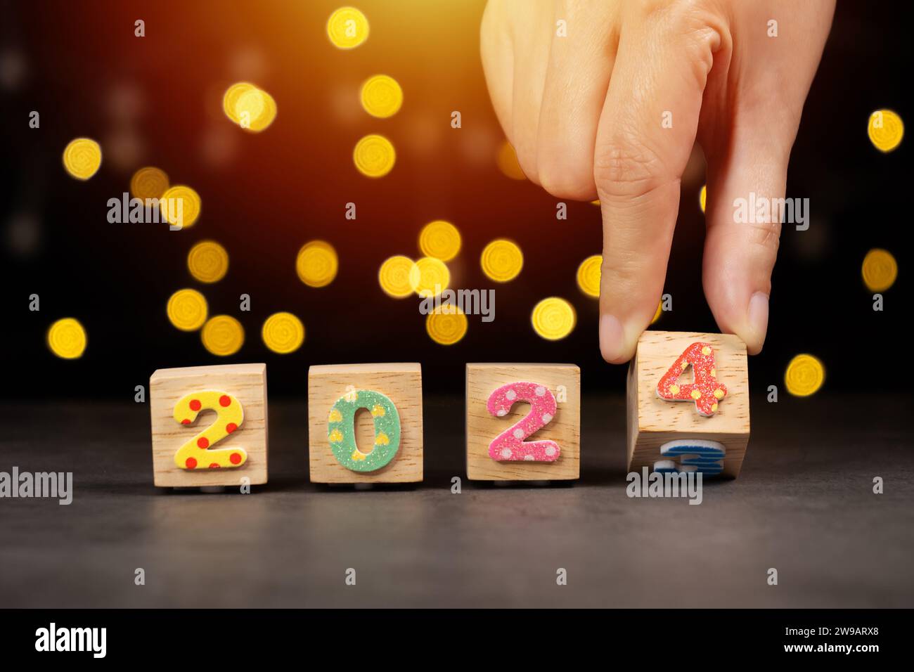hand flipping wooden cube block from year 2023 turn to year 2024. beginning and start of the new year 2024 for new year's eve countdown celebration Stock Photo