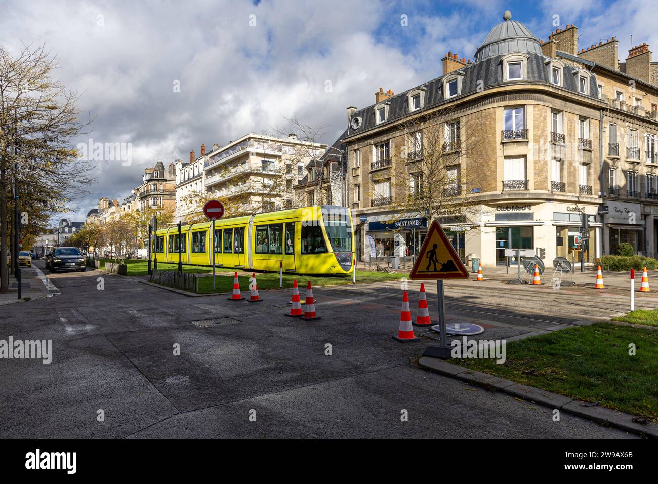 Photo of a yellow commuter train going  by in Reims, France Stock Photo