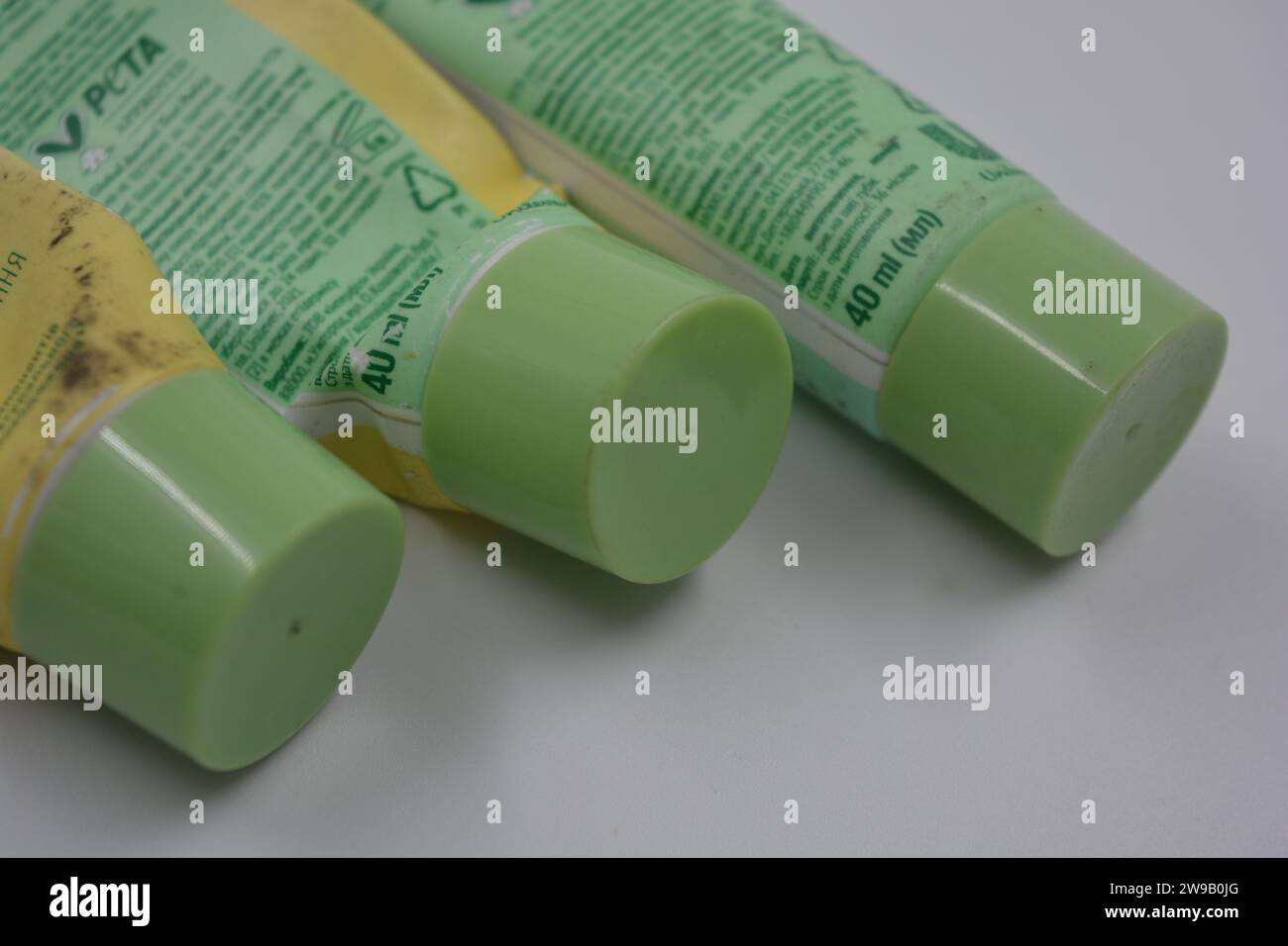 Women's cosmetics, three plastic, used tubes of face cream with three light green caps arranged