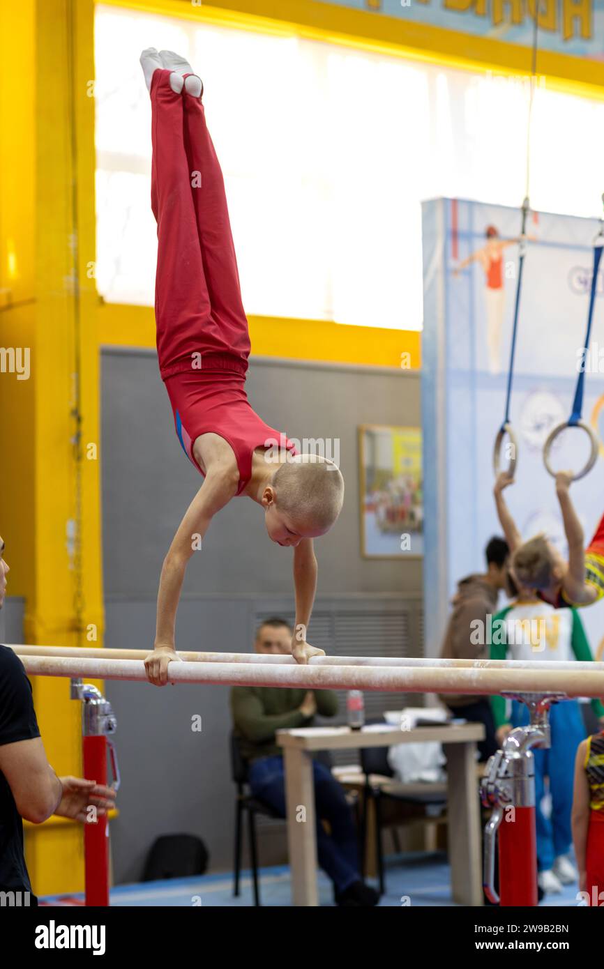 gymnast exercise parallel bars in championship gymnastics, boy handstanding on bars Stock Photo