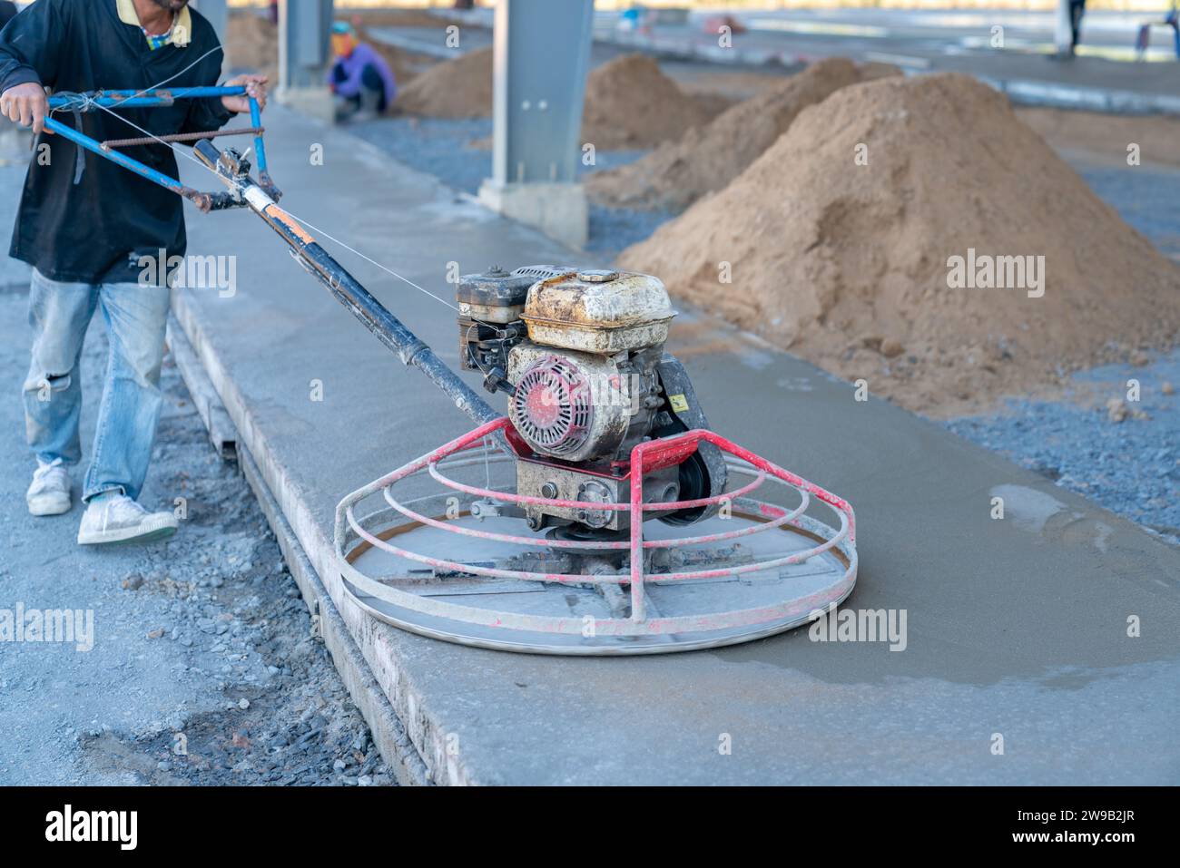 Construction worker grind the concrete surface after pour concrete