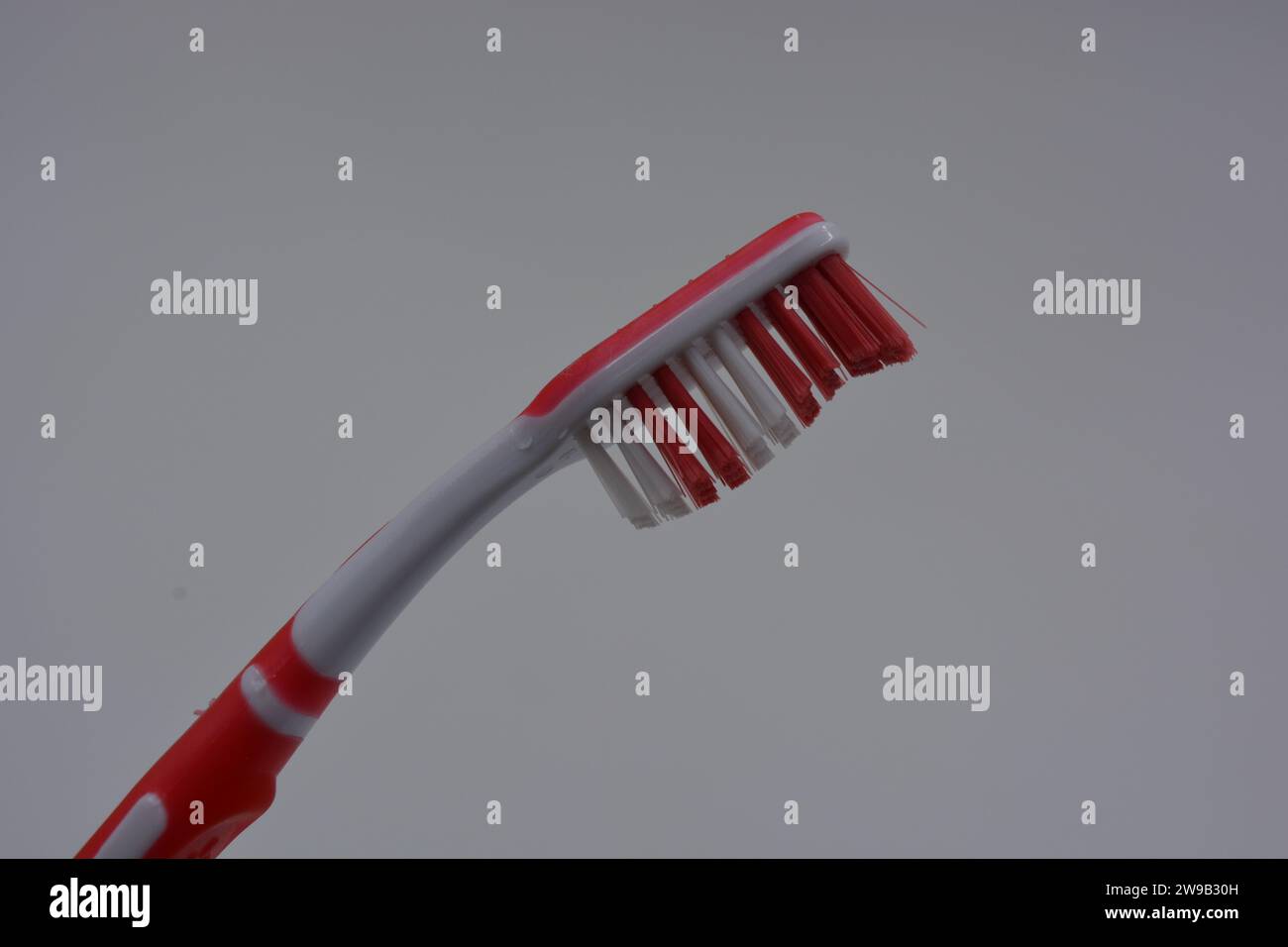 Personal hygiene products, a new plastic toothbrush with red and white ...