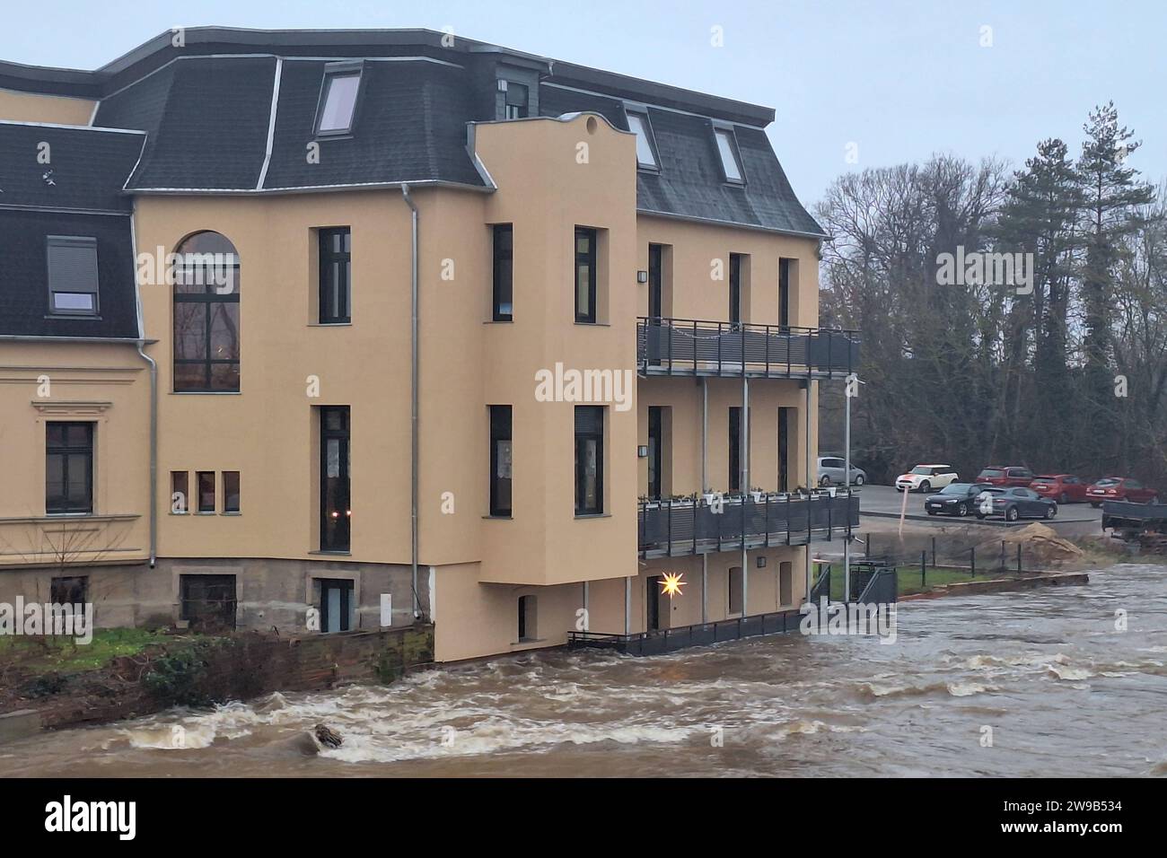 Raguhn-Jeßnitz - Hochwasser-Situation spitzt sich zu: Autos bleiben im Wasser stecken, erste Balkons geflutet 26.12.2023 gegen 10.30 Uhr Stadtgebiet Raguhn-Jeßnitz OT Jeßnitz Die Hochwasser-Situation im Kreis Anhalt-Bitterfeld Sachsen-Anhalt spitzt sich weiterhin zu: Seit dem Morgen tritt die Mulde in Jeßnitz bei Bitterfeld-Wolfen über die Ufer. Feuerwehren in der Region sind im Dauereinsatz, um vollgelaufene Keller und Garagen leer zu pumpen, Anwohner mit Sandsäcken zu versorgen sowie verschiedene Schutzmaßnahmen vorzunehmen. Einige Straßen sind bereits durch Wassermassen überflutet und für A Stock Photo