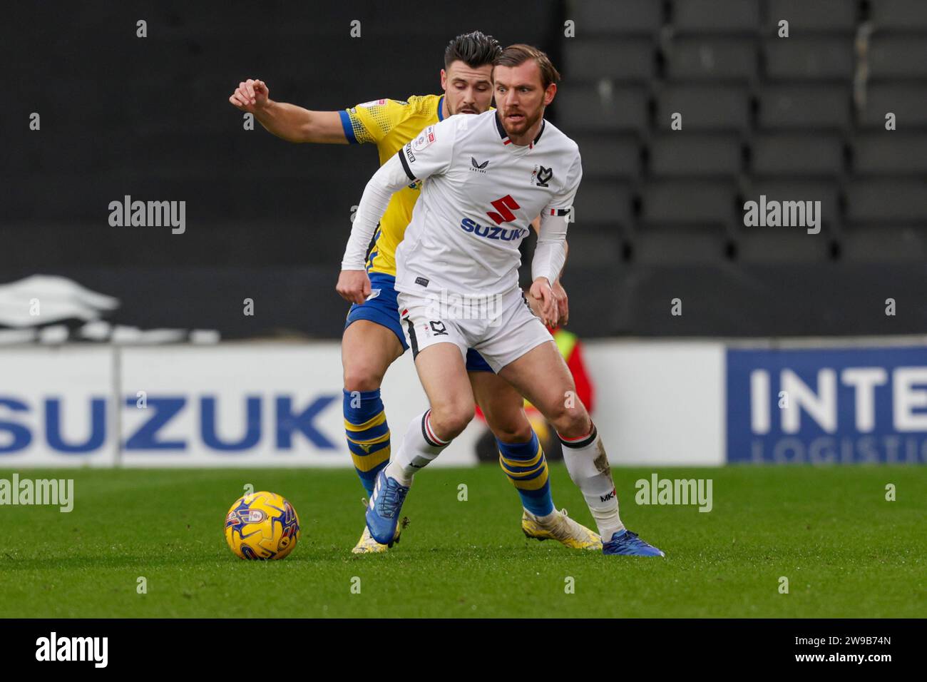 Milton Keynes Dons Alex Gilbey is challenged by Colchester United's captain Connor Hall during the first half of the Sky Bet League 2 match between MK Dons and Colchester United at Stadium MK, Milton Keynes on Tuesday 26th December 2023. (Photo: John Cripps | MI News) Credit: MI News & Sport /Alamy Live News Stock Photo