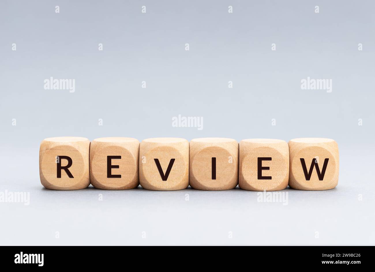 Review word on wooden blocks on gray background. Copy space Stock Photo