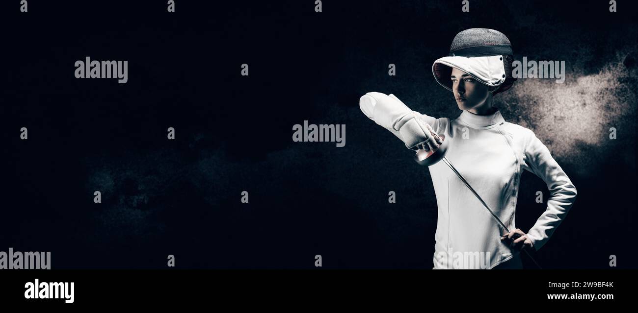 Charming girl dressed as a fencer posing with a mask and a sword. The