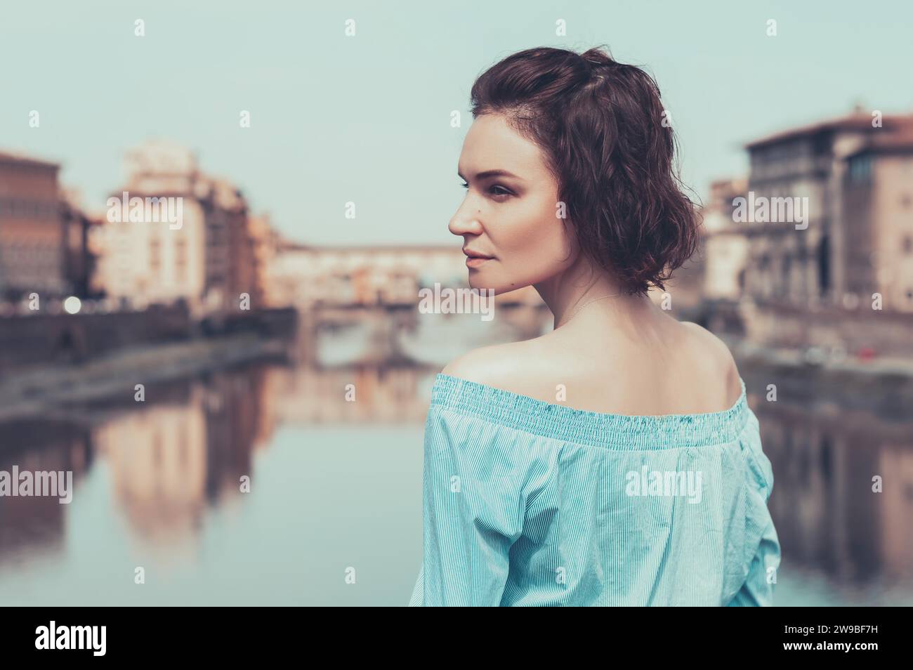 Portrait of a charming girl standing on a bridge in Florence. Arno River. View of the Ponte Vecchio. Tourism concept. Italy. Mixed media Stock Photo