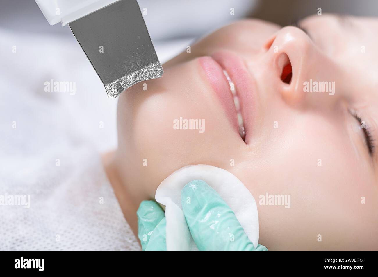 Young pretty woman receiving treatments in beauty salons. Ultrasonic cleaning procedure. Hardware cosmetology. Mixed media Stock Photo