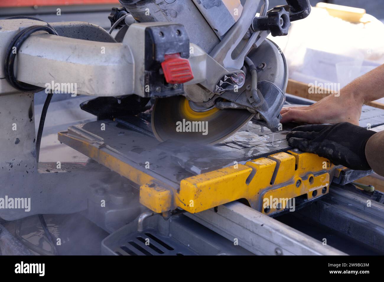 Cutting ceramic tiles with diamond blade saw machine by tiler Stock