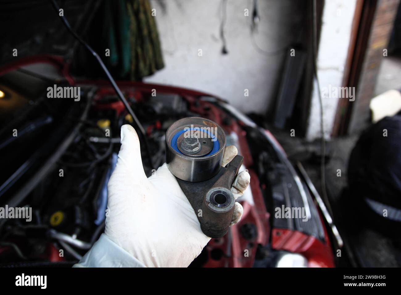 Replacing the tension roller of a car's timing system, mechanic, glove