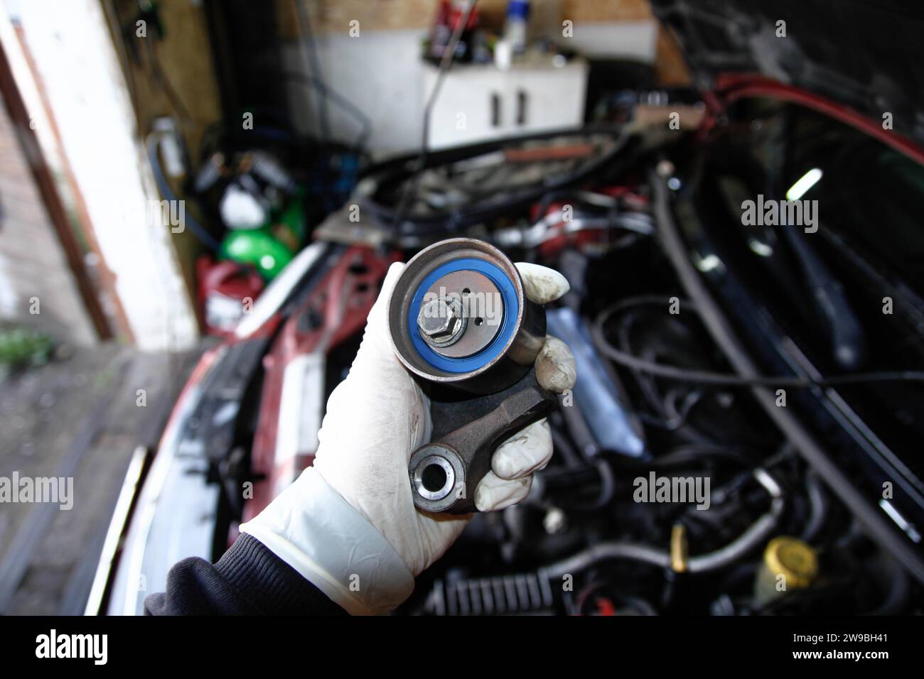 Replacing the tension roller of a car's timing system, mechanic, glove