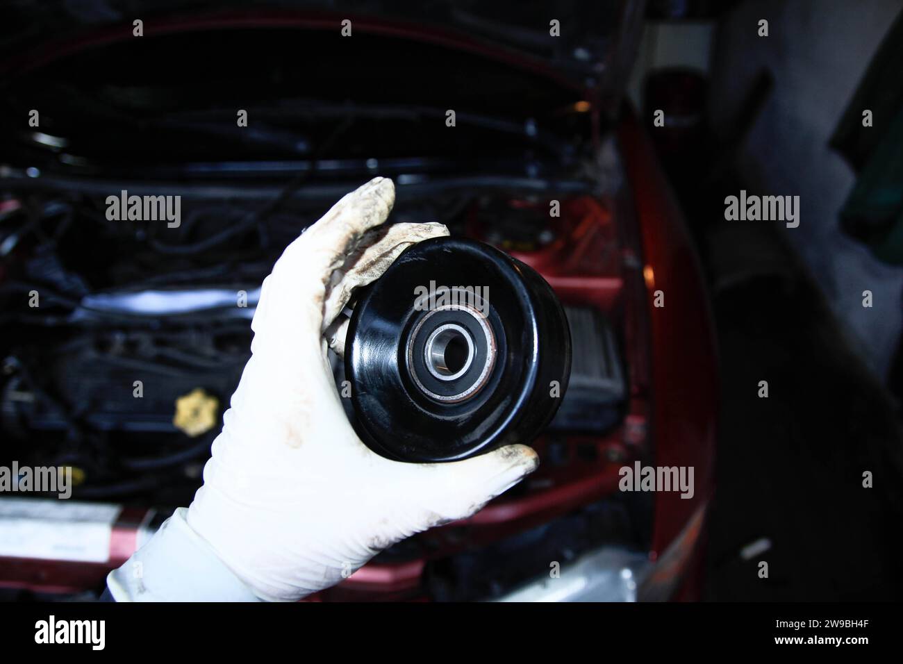 Replacing the tension roller of a car's timing system, mechanic, glove
