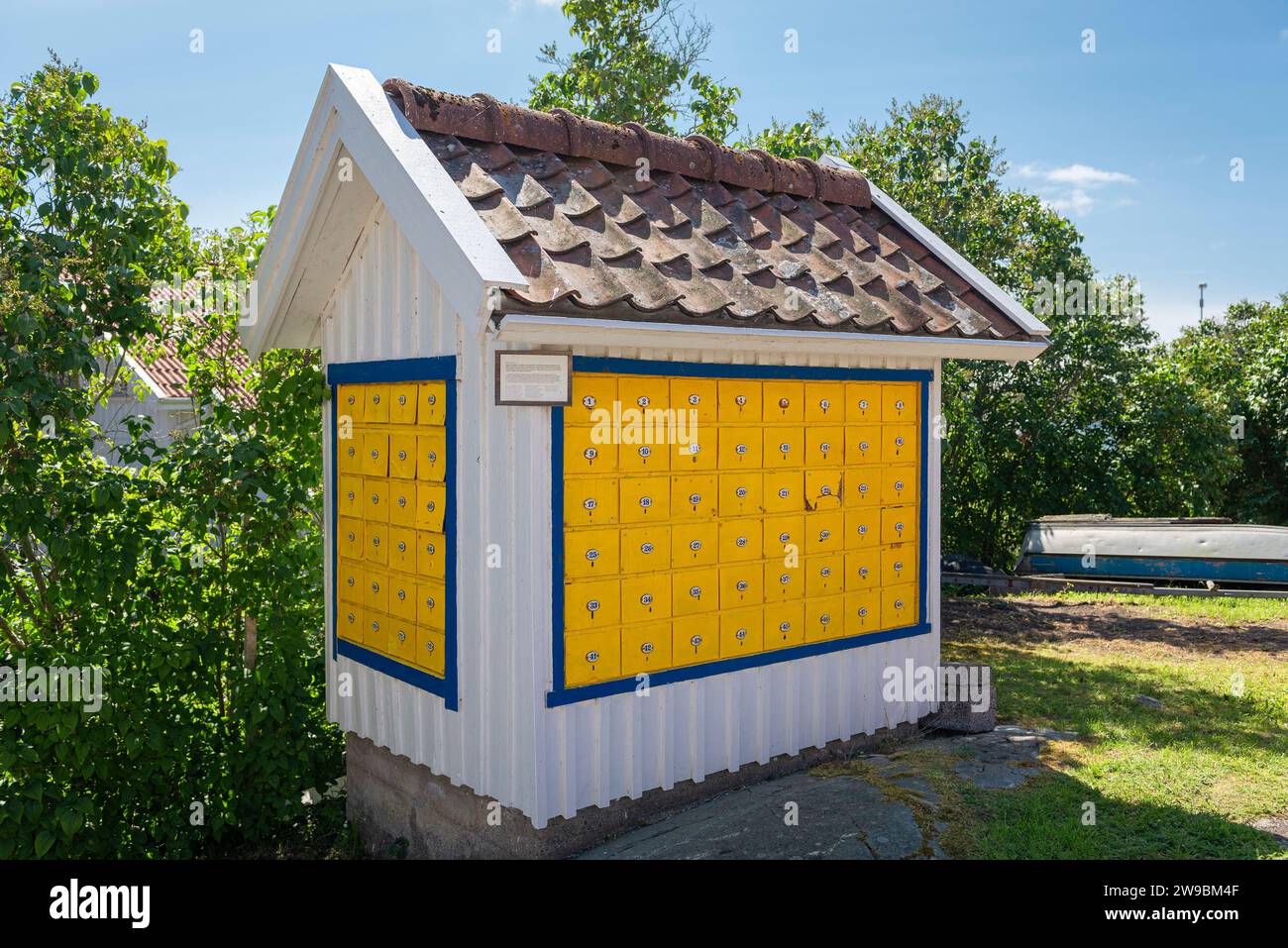 White wooden hut with numbered yellow post boxes in the harbour town of Stocken on the island of Orust on the west coast of Sweden Stock Photo