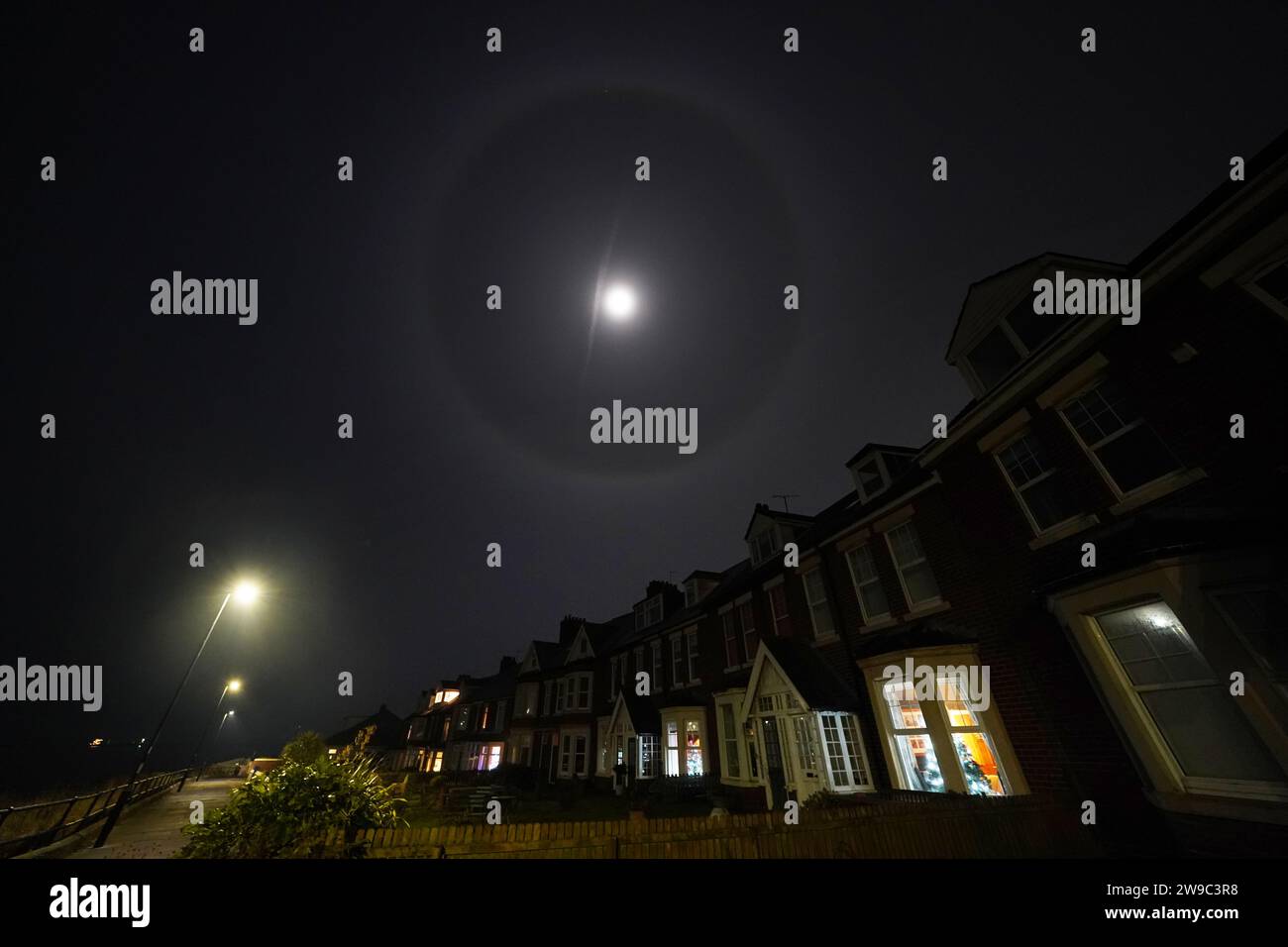 A Lunar halo surrounds the moon, as ice crystals in the atmosphere refract light above Whitley Bay, north east England. Picture date: Tuesday December 26, 2023. Stock Photo