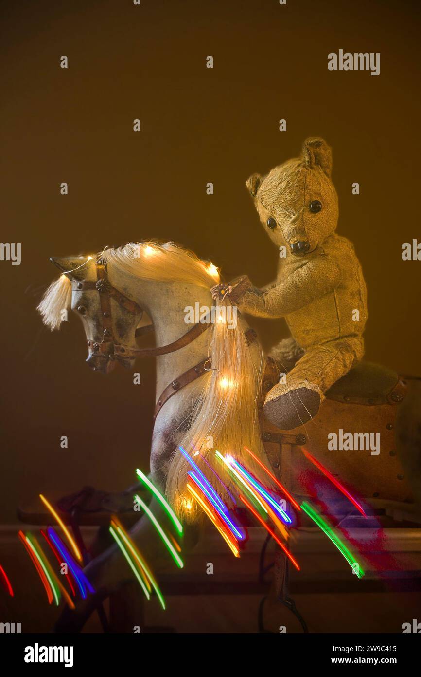 Teddy bear riding traditional wooden Rocking Horse with horsehair mane, Stock Photo