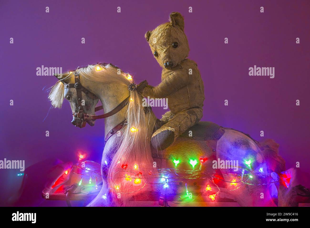 Teddy bear riding traditional wooden Rocking Horse with horsehair mane, Stock Photo