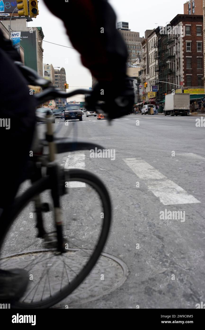 a bicyclist cuts in front of a photographer on the street in lower Manhattan Stock Photo