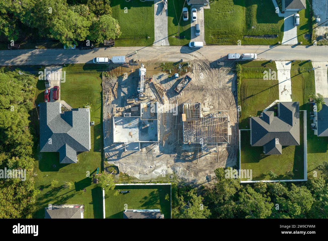 Builders working on roof construction of unfinished residential house with wooden frame structure in Florida suburban area. Housing development Stock Photo